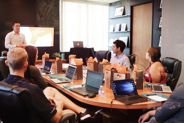 Staff meeting watching a presenter at the front.