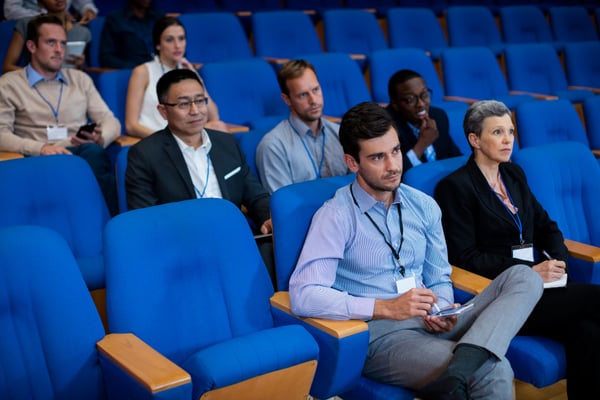 Many employees sitting in an auditorium to watch new employee orientation